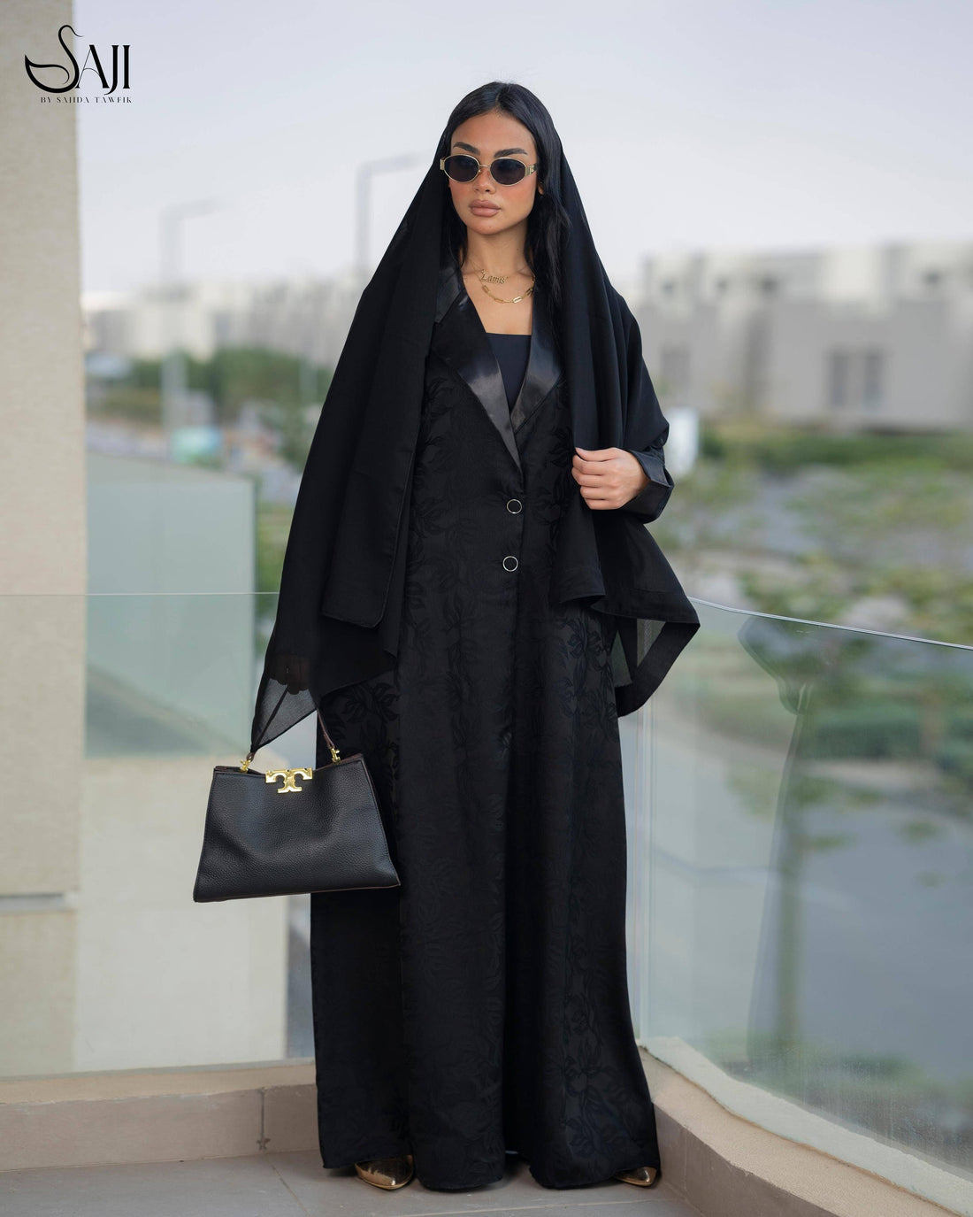 Stylish Tala Jacquard Abaya with a modern Korean touch, showcasing a sophisticated black design with satin lapels and a matching scarf.